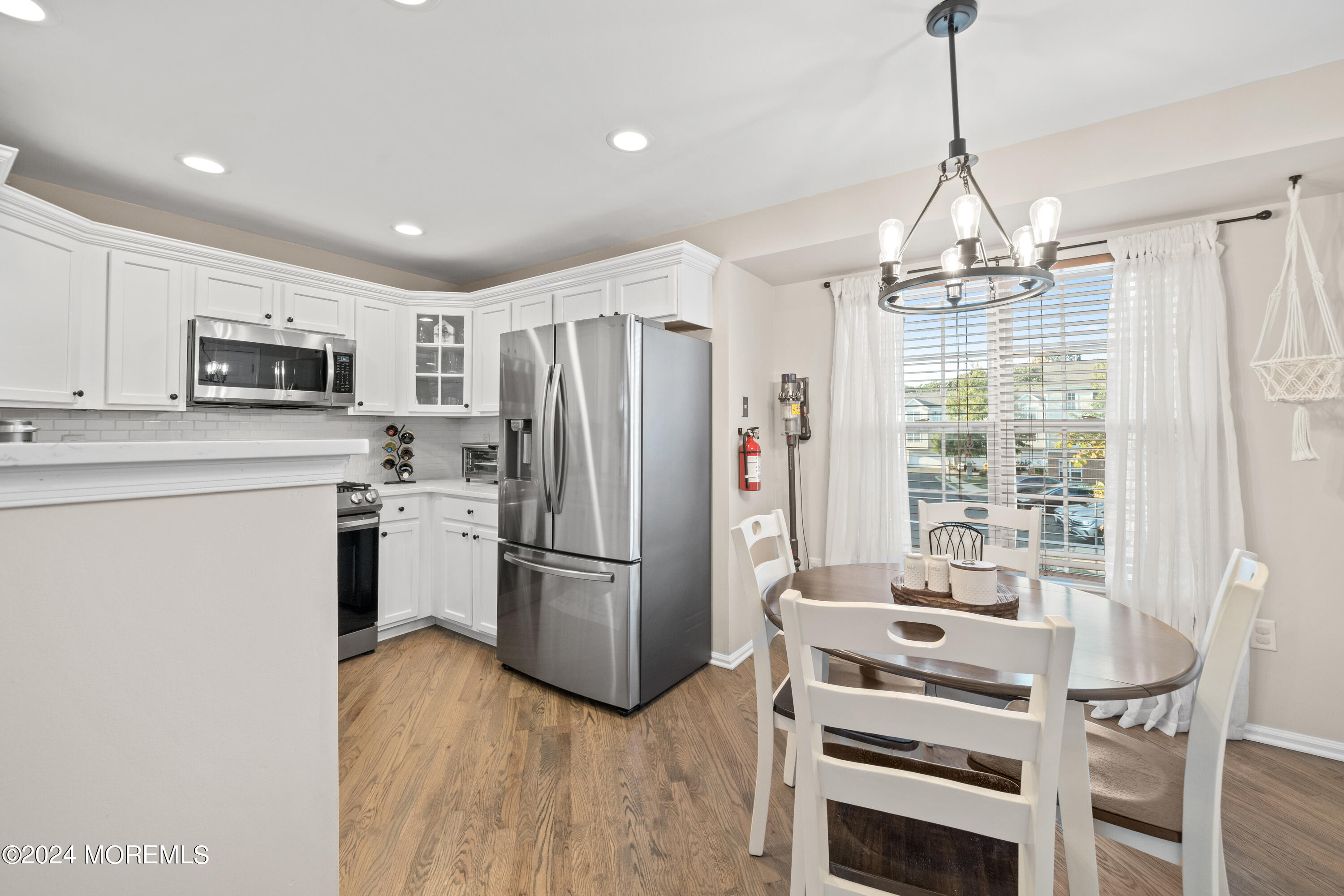 5 Kuczynski Drive, Unit 945 Parlin, NJ 08859 - Photo 11 of 62 a kitchen with kitchen island a refrigerator a stove a microwave and wooden floor