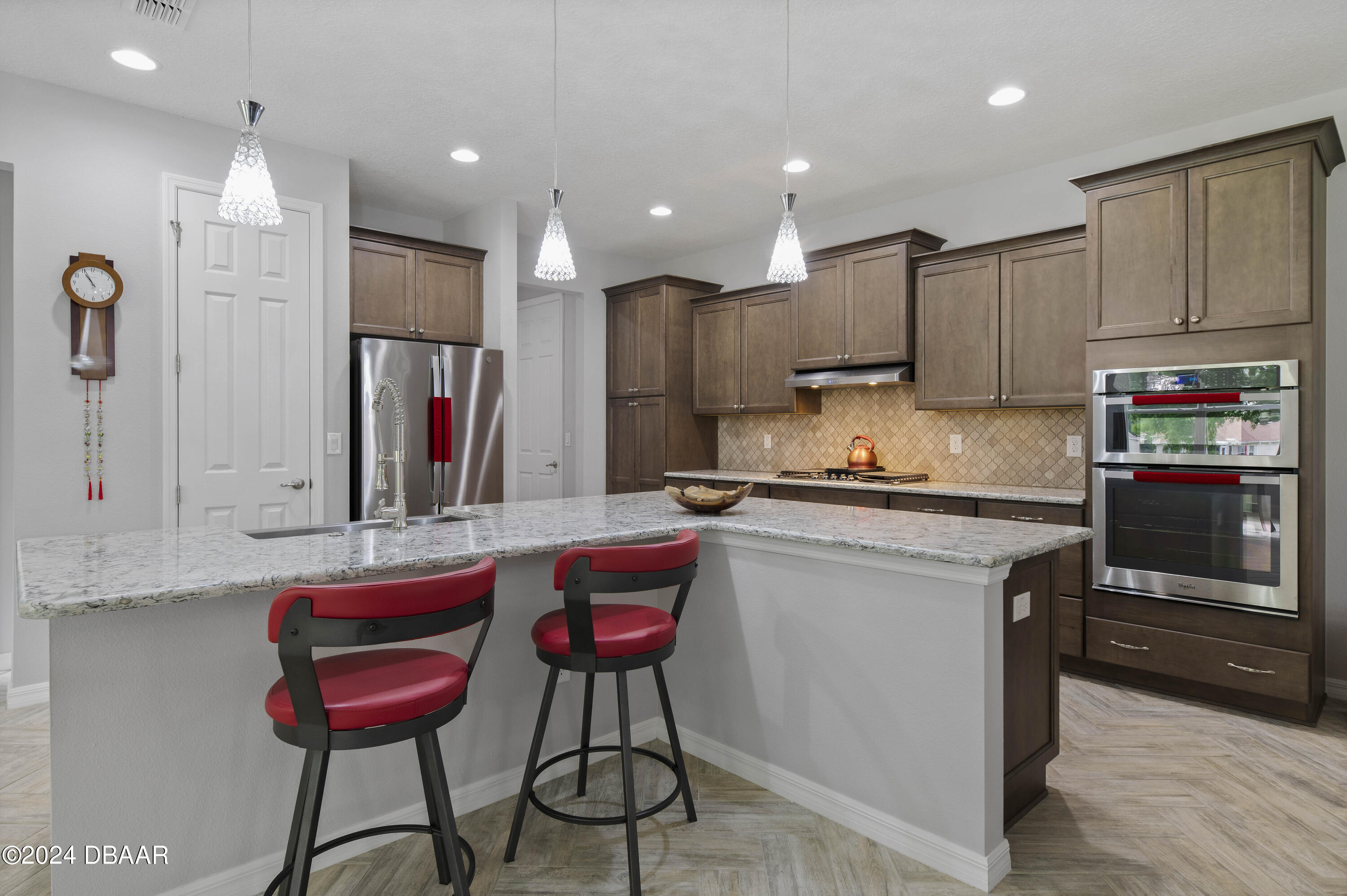 9794 Southwest 92 Street Ocala, FL 34481 - Photo 18 of 39 a kitchen with kitchen island granite countertop wooden cabinets and stainless steel appliances