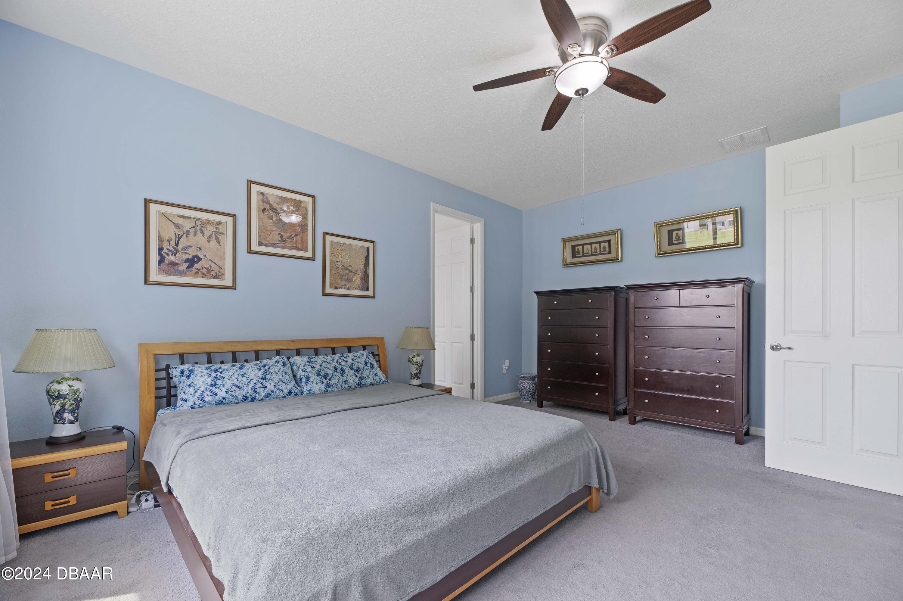9794 Southwest 92 Street Ocala, FL 34481 - Photo 27 of 39 a bedroom with a bed and a chandelier