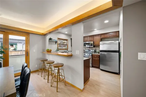 a kitchen with refrigerator and chairs
