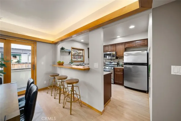 a kitchen with refrigerator and chairs