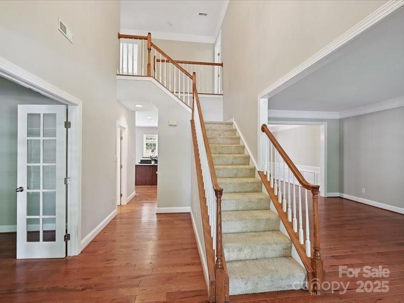 6932 Augustine Way Charlotte, NC 28270 - Photo 2 of 46 a view of staircase with lots of frames on wall and wooden floor