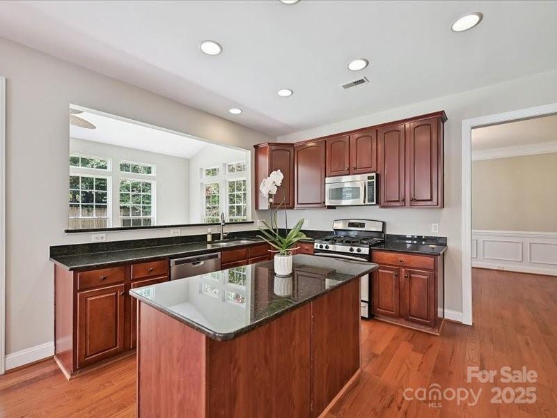 6932 Augustine Way Charlotte, NC 28270 - Photo 25 of 46 a kitchen with granite countertop stainless steel appliances and wooden cabinets