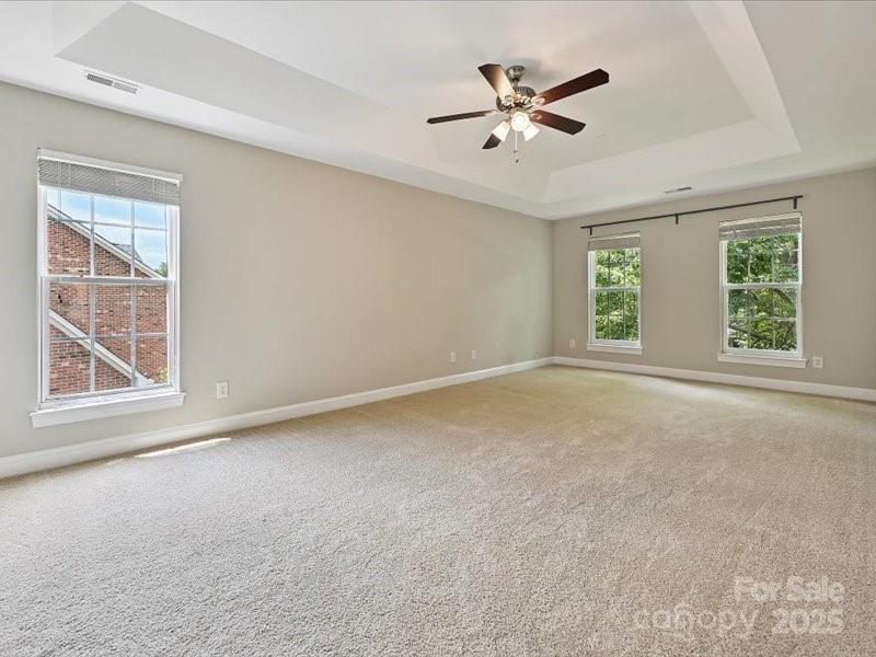 6932 Augustine Way Charlotte, NC 28270 - Photo 29 of 46 an empty room with ceiling fan and windows