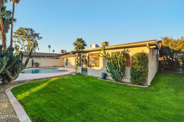 a view of a swimming pool with a patio and a yard