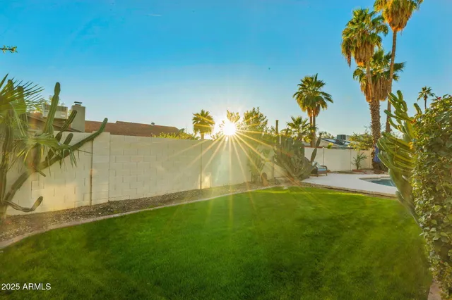 a view of a swimming pool with a table and chairs under an umbrella