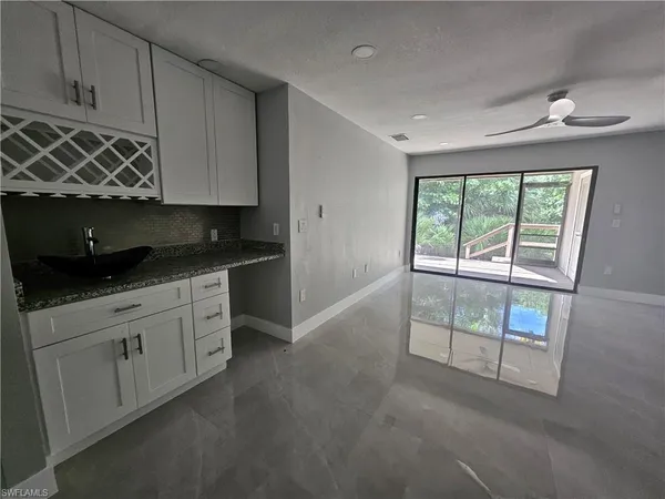 a kitchen with granite countertop a stove a sink and a microwave