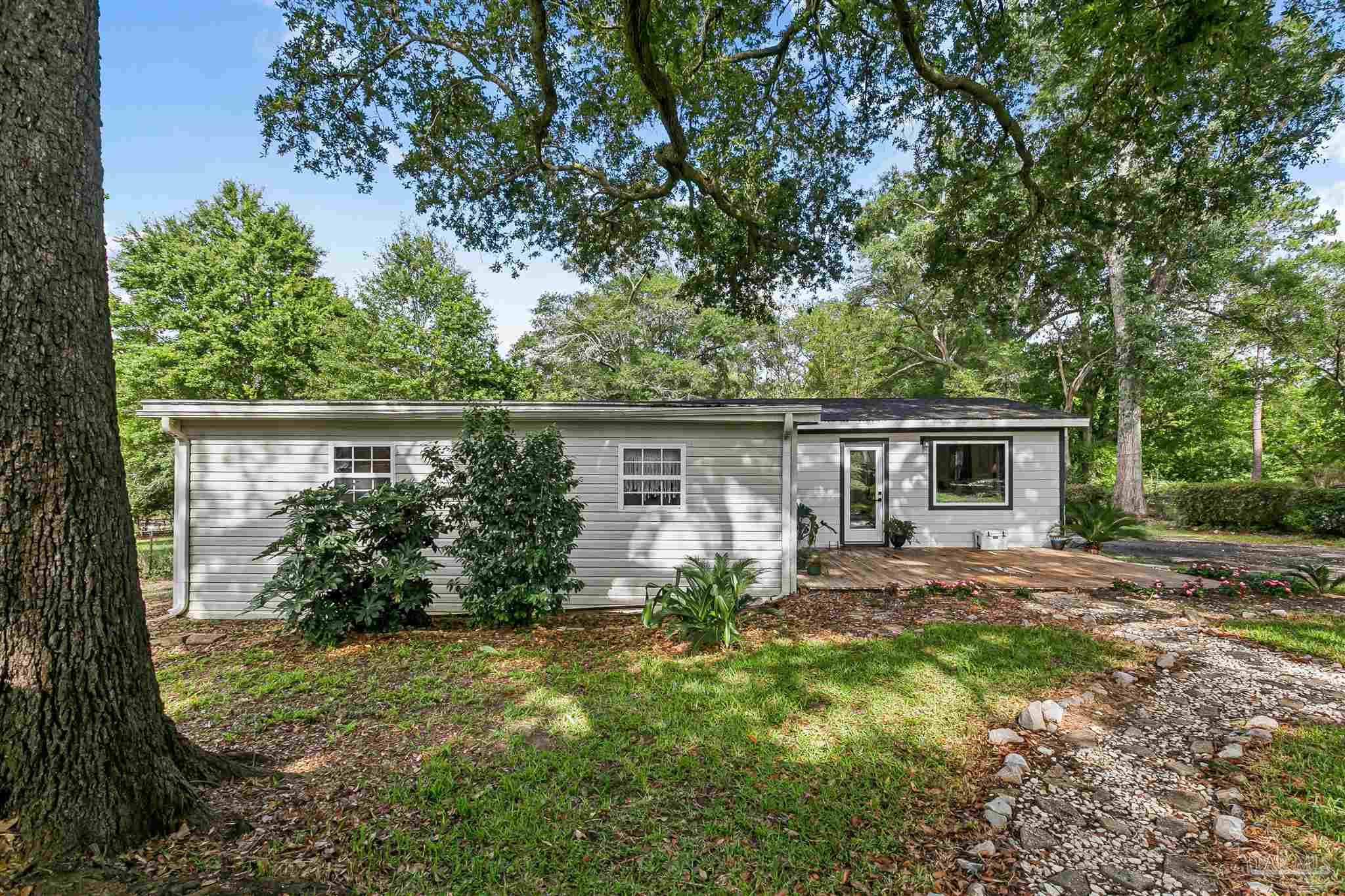 1095 River Annex Road Cantonment, FL 32533 - Photo 30 of 32 a view of a house with yard and a garden