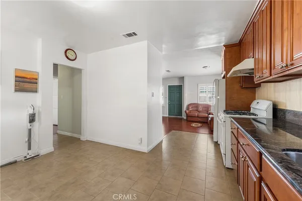 a kitchen with stainless steel appliances granite countertop a sink dishwasher stove and refrigerator