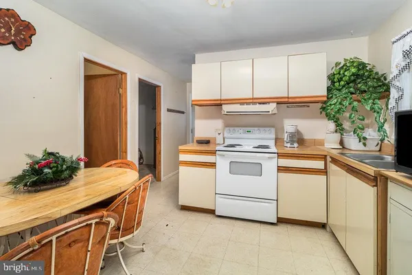a kitchen with a white stove and white cabinets