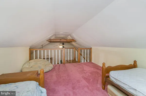 a bedroom with a bed and a dresser with rug