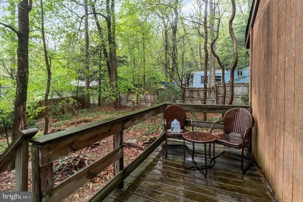 a balcony with wooden floor and outdoor seating