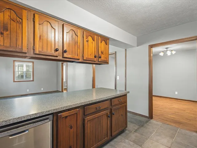 a view of an empty room with window and chandelier fan