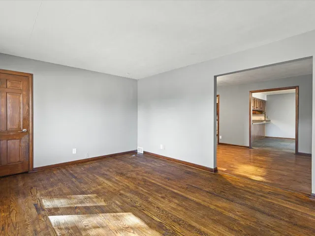 a view of an empty room and wooden floor