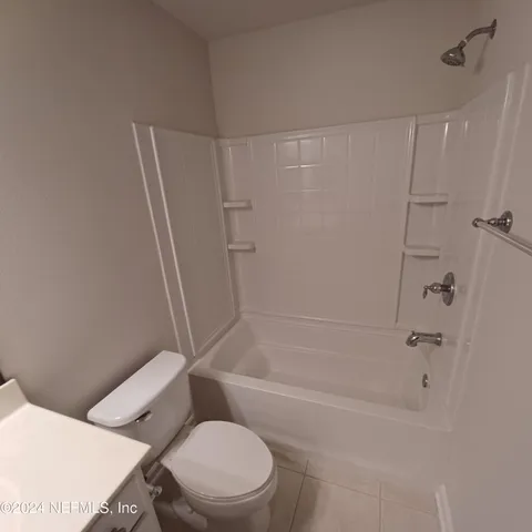 a white toilet and tub sitting next to a bathroom sink