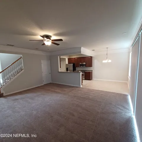 a view of a livingroom with furniture and chandelier fan