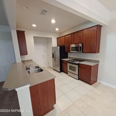a kitchen with stainless steel appliances granite countertop a stove a sink and a refrigerator