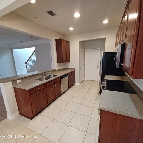 a kitchen with stainless steel appliances a stove a sink and a refrigerator