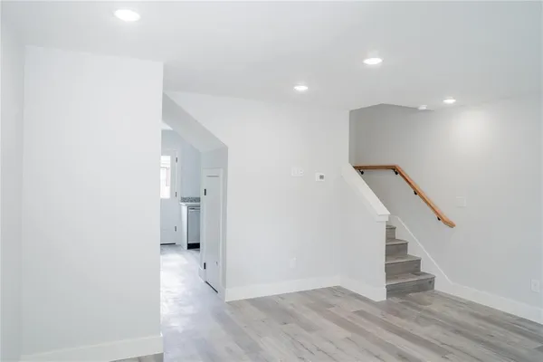 a view of hallway with stairs and wooden floor