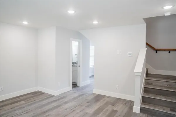 a view of an empty room with wooden floor and entryway