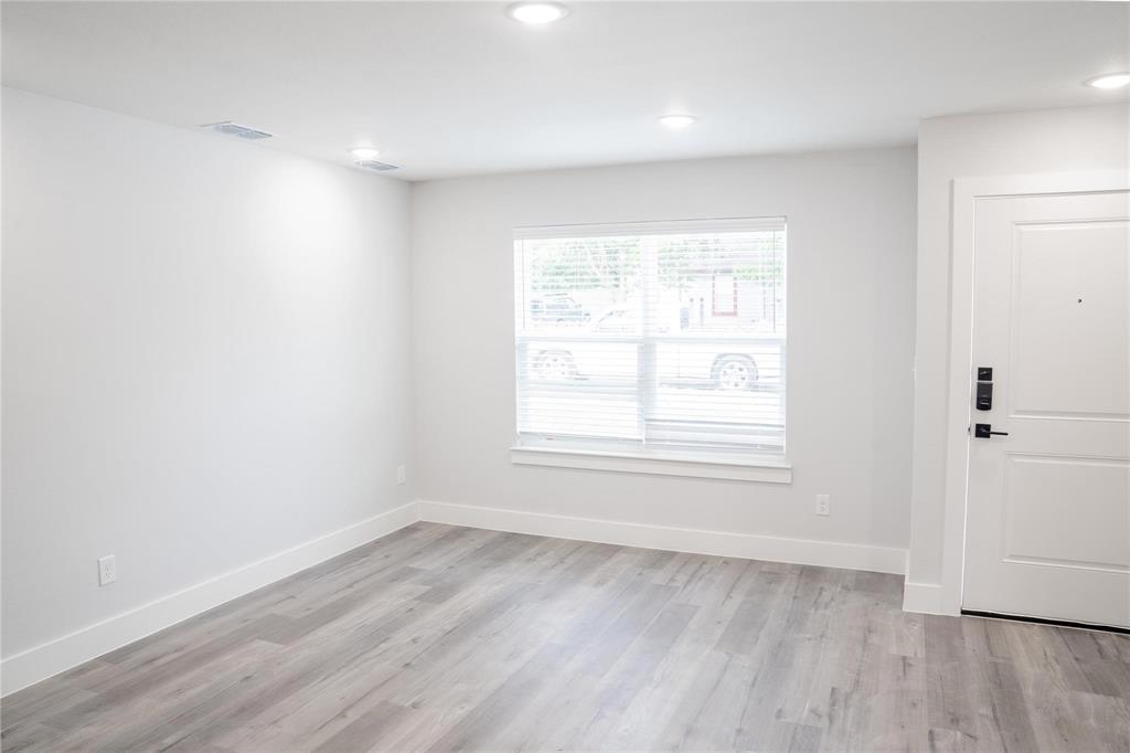 318 Henderson Street Bonham, TX 75418 - Photo 7 of 12 an empty room with wooden floor and windows