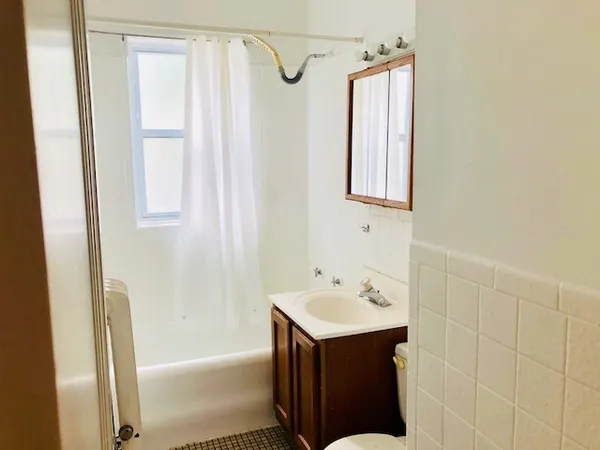 a bathroom with a sink vanity tub and shower