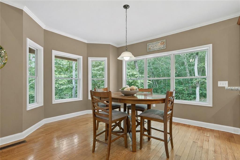 3184 St. Andrews Way Ellijay, GA 30536 - Photo 22 of 51 a view of a dining room with furniture large windows and wooden floor