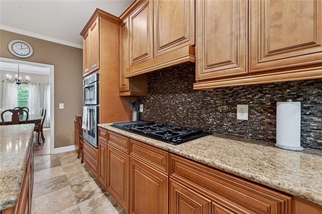 3184 St. Andrews Way Ellijay, GA 30536 - Photo 24 of 51 a kitchen with granite countertop a stove top oven microwave and cabinets