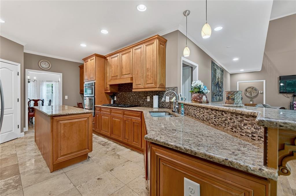 3184 St. Andrews Way Ellijay, GA 30536 - Photo 25 of 51 a kitchen with stainless steel appliances granite countertop wooden cabinets and a stove top oven