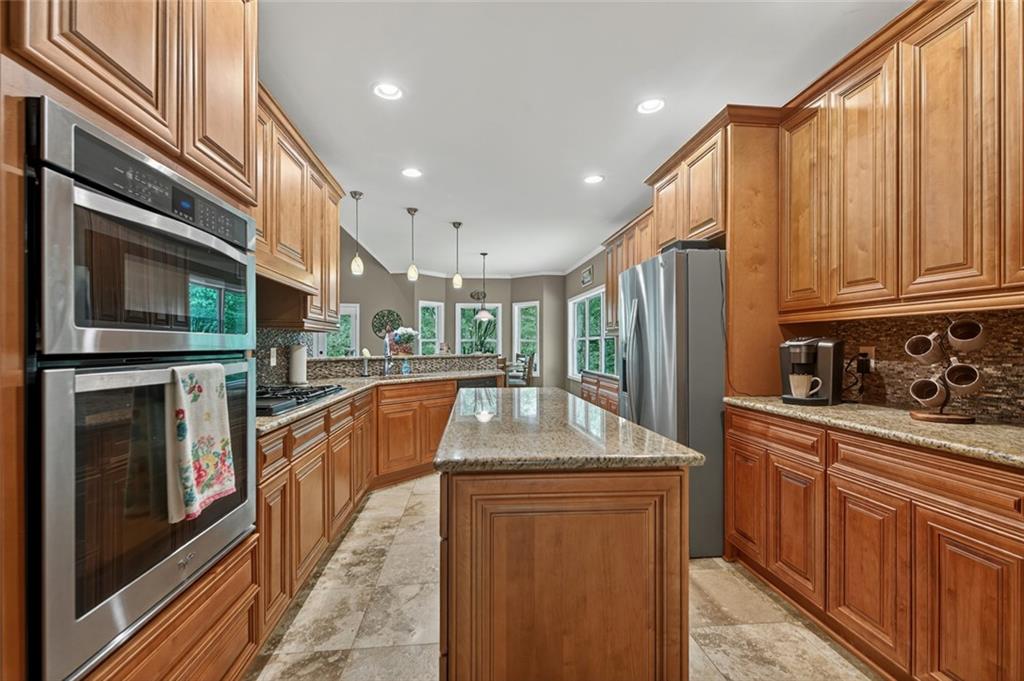 3184 St. Andrews Way Ellijay, GA 30536 - Photo 26 of 51 a kitchen with stainless steel appliances granite countertop a refrigerator a stove and a sink with wooden cabinets