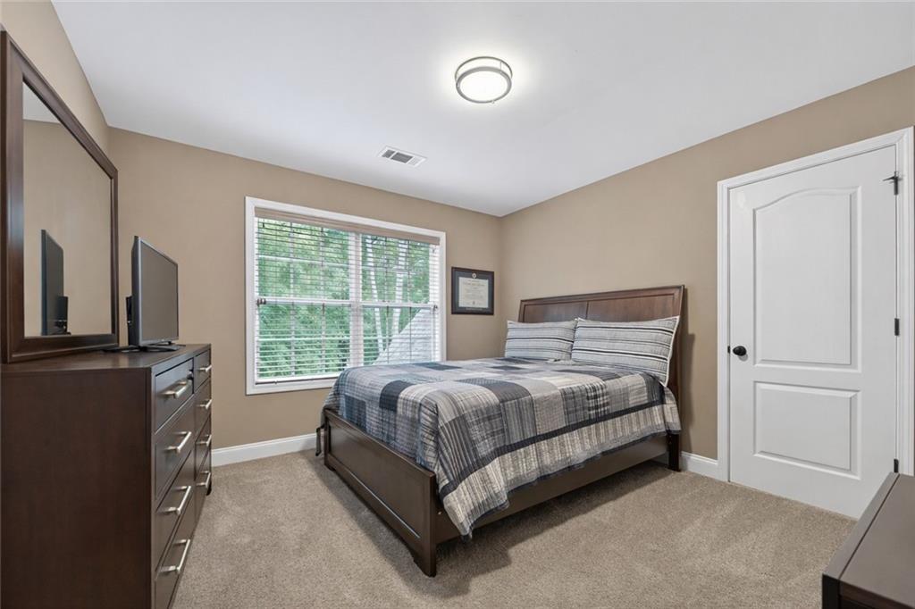 3184 St. Andrews Way Ellijay, GA 30536 - Photo 38 of 51 a bed sitting in a bedroom next to a window