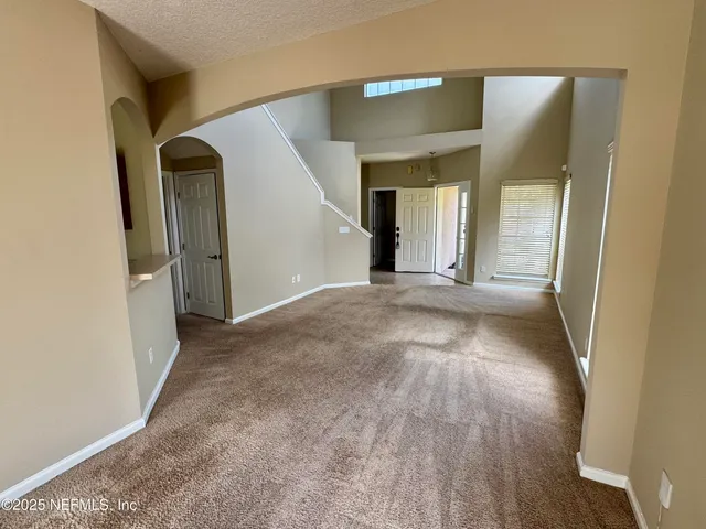 a view of a hallway with wooden floor and a bathroom