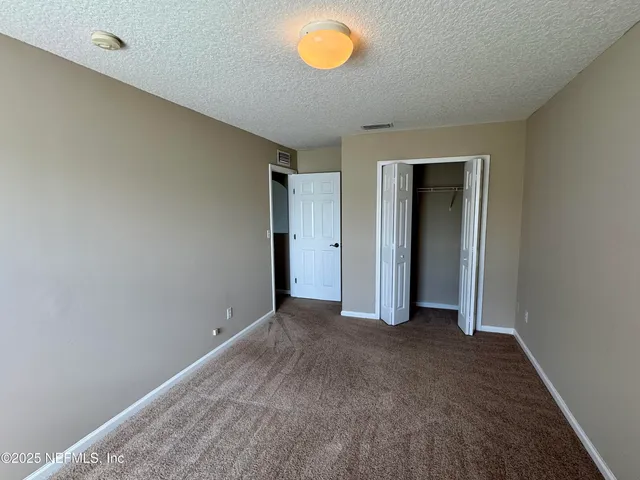 an empty room with window and mirror