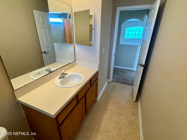 a bathroom with a sink vanity granite and a mirror