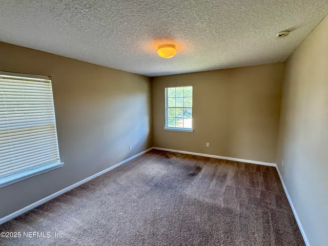 an empty room with windows and closet