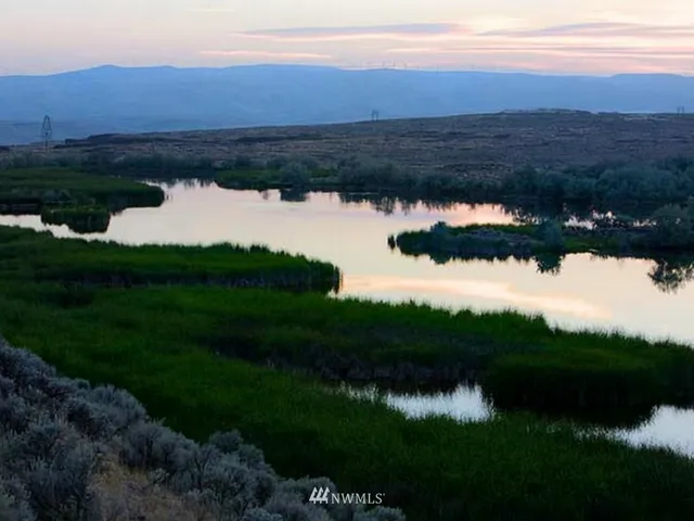 a view of lake with green yard