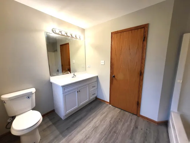 a bathroom with a granite countertop toilet sink and mirror
