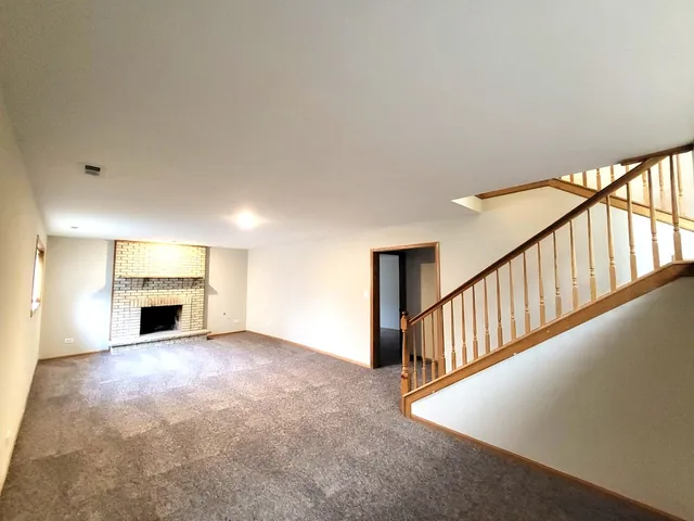 a view of an empty room with a fireplace and a window