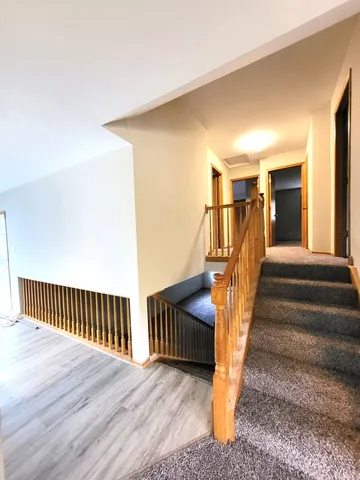 a view of a livingroom with wooden floor and stairs