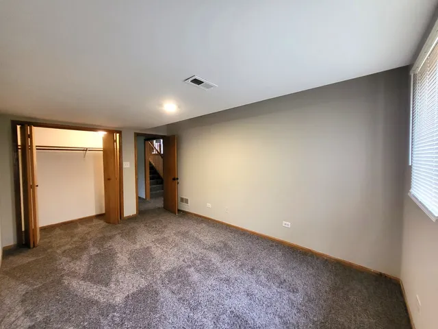 an empty room with an entryway and closet