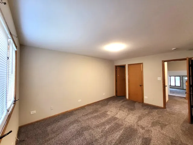 an empty room with closet and windows