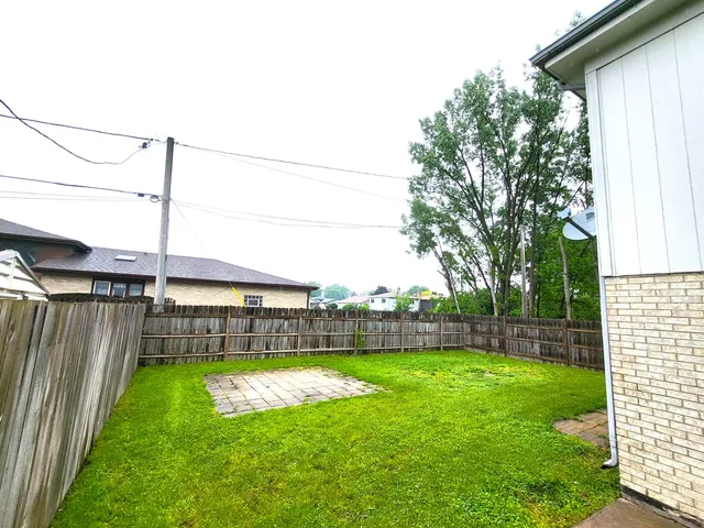 a view of a backyard with a garden and entertaining space
