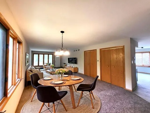 a dining room with furniture a chandelier and wooden floor