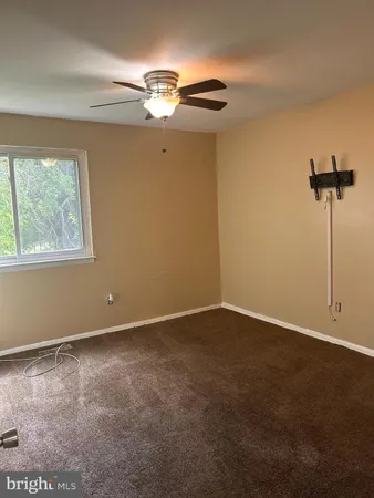 a view of an empty room with a chandelier fan