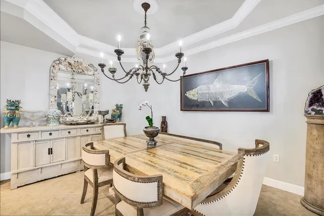 a dining room with wooden floor a chandelier a wooden table and chairs