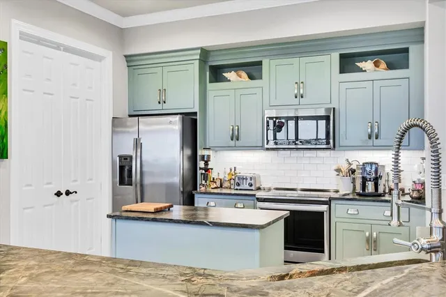 a kitchen with stainless steel appliances granite countertop a sink stove and refrigerator
