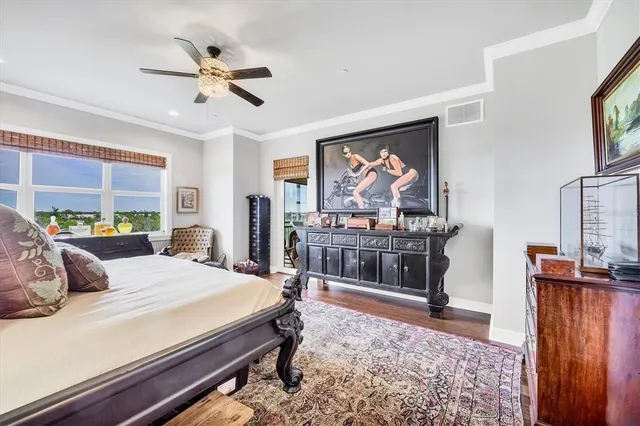 a bedroom with a bed a dresser and potted plants