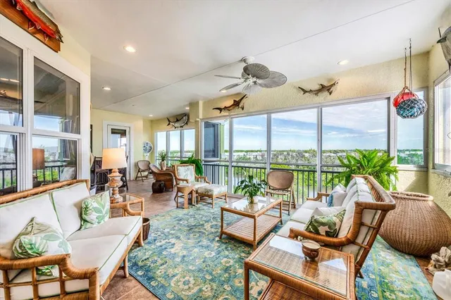 a dining room with furniture water view and a floor to ceiling window