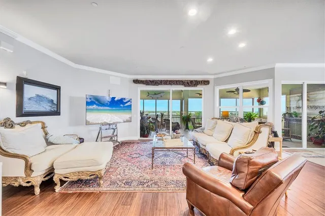 a living room with furniture large wooden floor and a large window