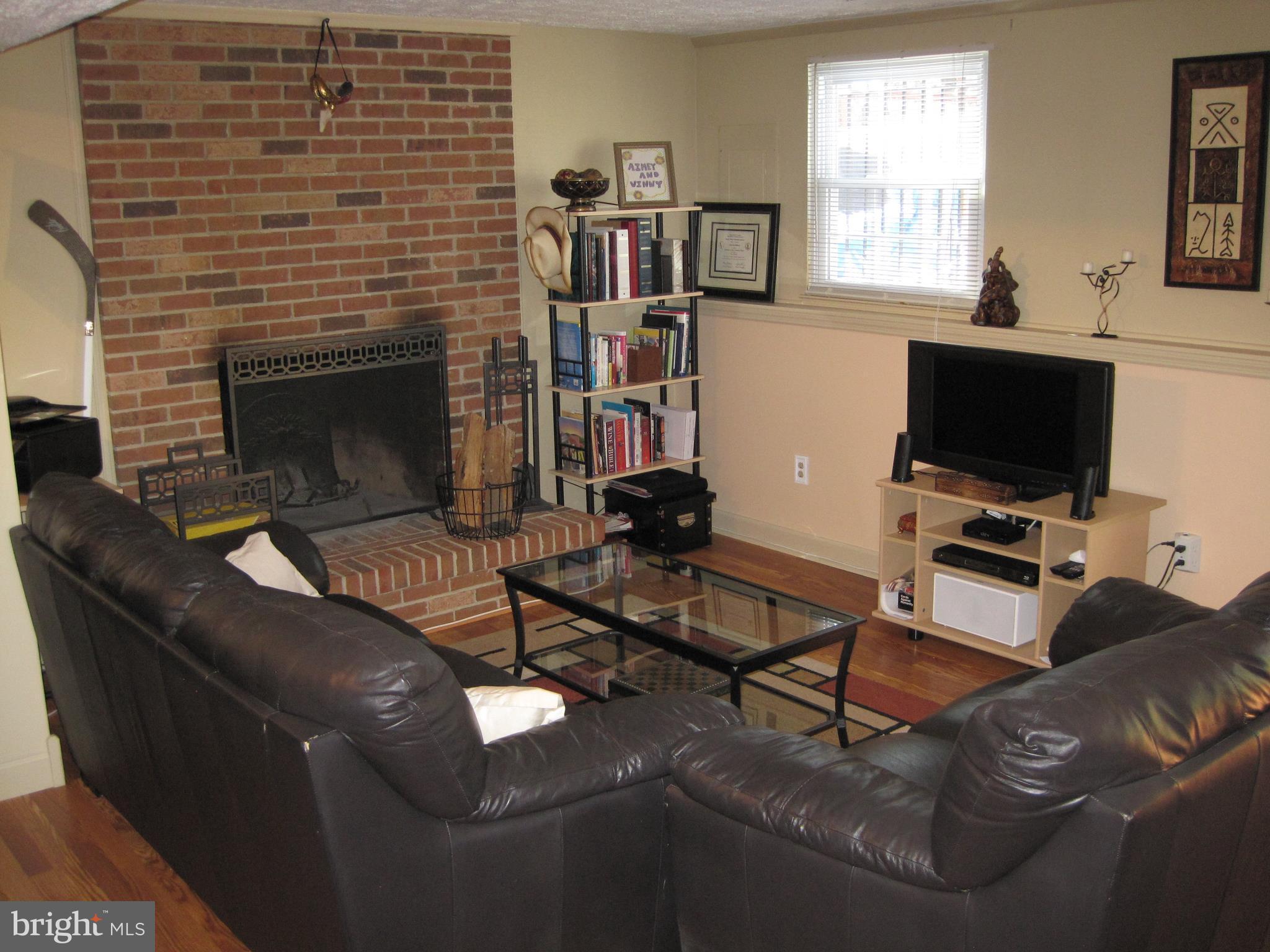 6178 Morning Glory Road Alexandria, VA 22310 - Photo 20 of 26 a living room with furniture a flat screen tv and a fireplace